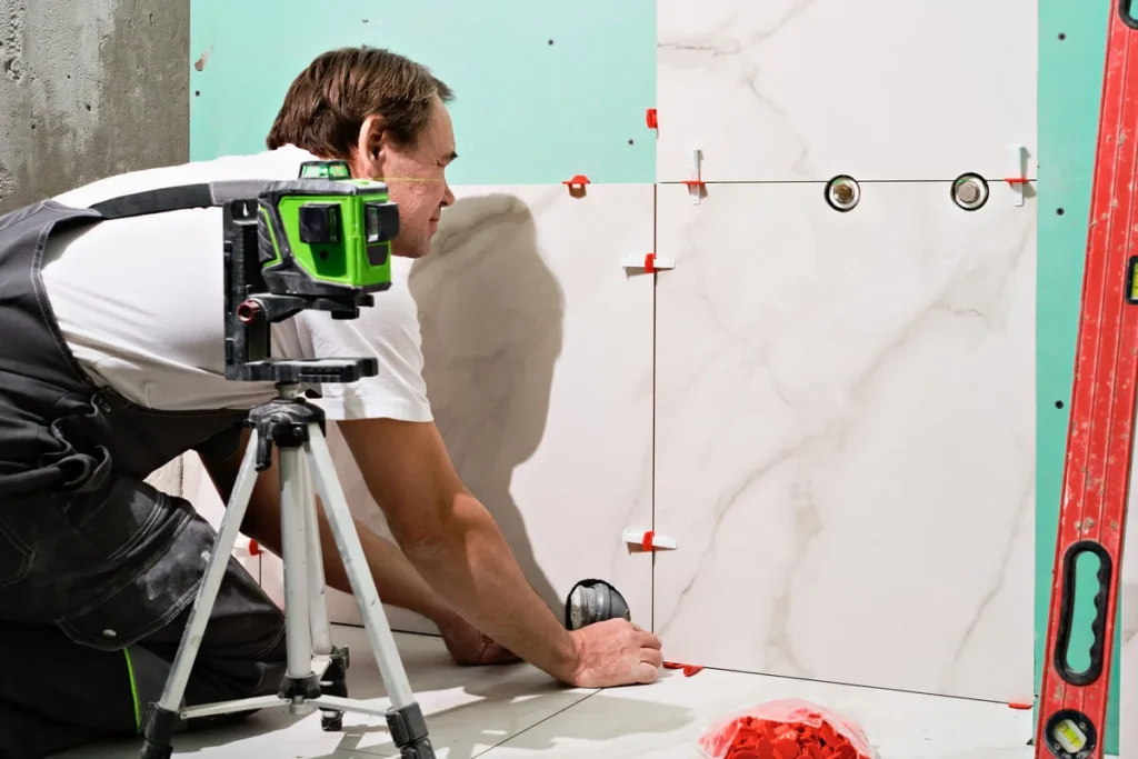 man laying ceramic tiles wall bathroom portrait